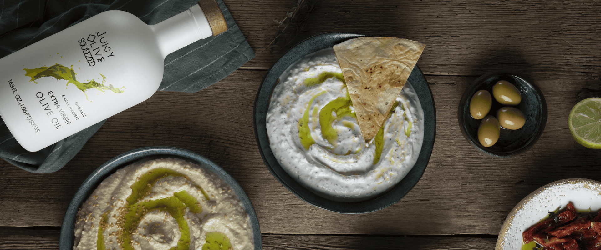 Premium high-phenolic olive oil bottle and fresh olives on a marble counter, showcasing luxury wellness and health.